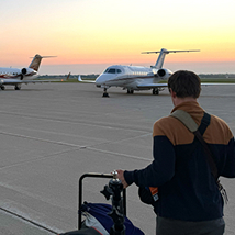 R3 person walking towards plane with luggage